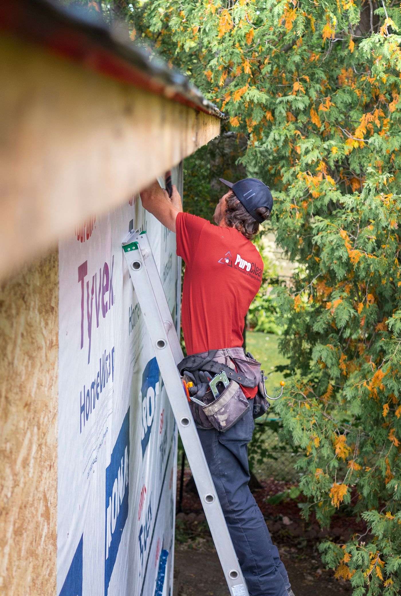 Contractor installing siding and house wrap on a home
